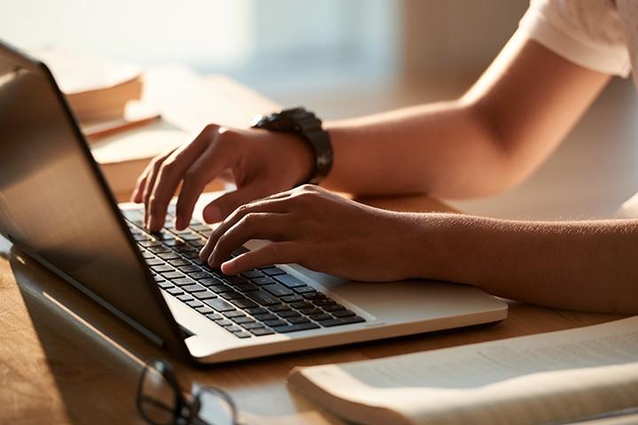 Student typing on laptop